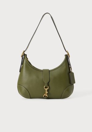 Petit sac à épaule en cuir vert olive avec fermoir doré, forme courbée, bandoulière courte noire réglable et une étiquette en cuir suspendue.
