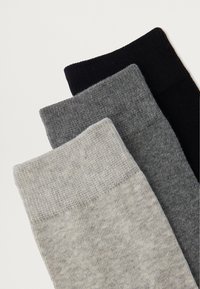 Kolme sokkipaari heledas hallis, tumes hallis ja mustas. Iga sokk sisaldab sooniku äärt ja pehmet, tekstuurset kudumismaterjali.