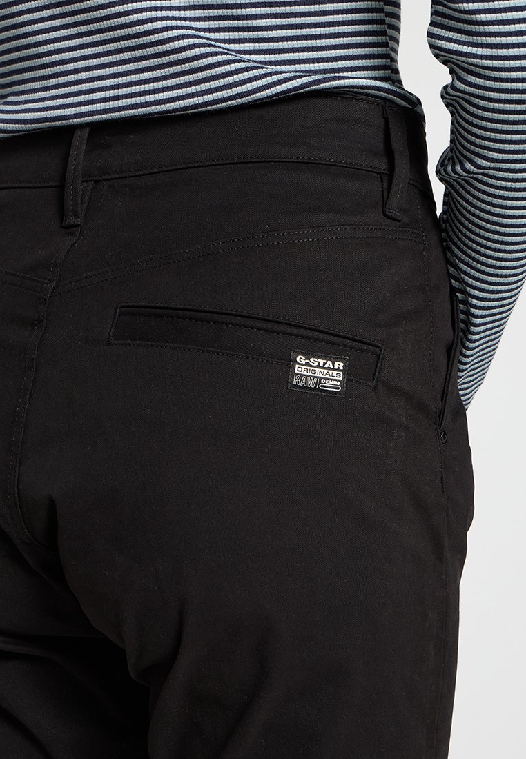 Pantalons en denim noir à coupe slim, avec une poche arrière portant une étiquette logo G-Star et de subtils détails de couture.