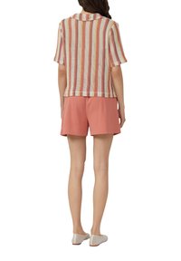 Gebreide top met korte mouwen en meerkleurige strepen (roze, geel, roomkleurig) gecombineerd met lichtroze shorts; casual, ontspannen pasvorm.