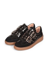 Zwarte sneakers van een combinatie van suède en lakleer, met drie verstelbare banden met metalen gespen en ronde uitsparingen. Bruine zool.