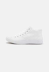 Zapatillas altas blancas con suelas de goma, diseño de cordones, parte superior sintética lisa, punta redondeada y capuchón de punta texturizado. Estilo minimalista.