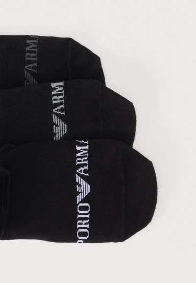 Τρία ζευγάρια μαύρες κάλτσες με λευκό κείμενο και λογότυπο "Emporio Armani" διπλωμένα δίπλα το ένα στο άλλο πάνω σε λευκό φόντο.