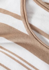 Tissu rayé en blanc et marron clair, présentant une texture douce et un col rond avec une finition de couture soignée.