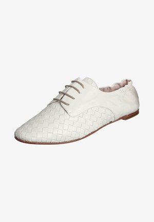 Chaussure blanche en cuir tressé à lacets avec bout pointu et semelle plate marron.