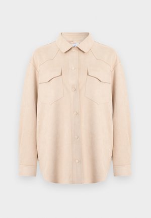 Μπεζ ανοιχτόχρωμο πουκάμισο με μακριά μανίκια, κουμπιά μπροστά, γιακά και δύο τσέπες στο στήθος με καπάκια, απεικονισμένο σε απλό ανοιχτό φόντο.