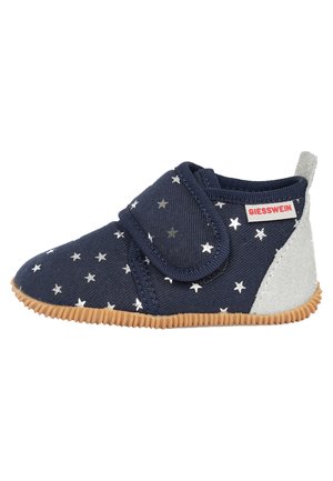 Chaussure en tissu navy avec motif d'étoiles argentées, bande auto-agrippante, talon en suède gris et semelle en caoutchouc texturé. Bout rond et design à coupe basse.