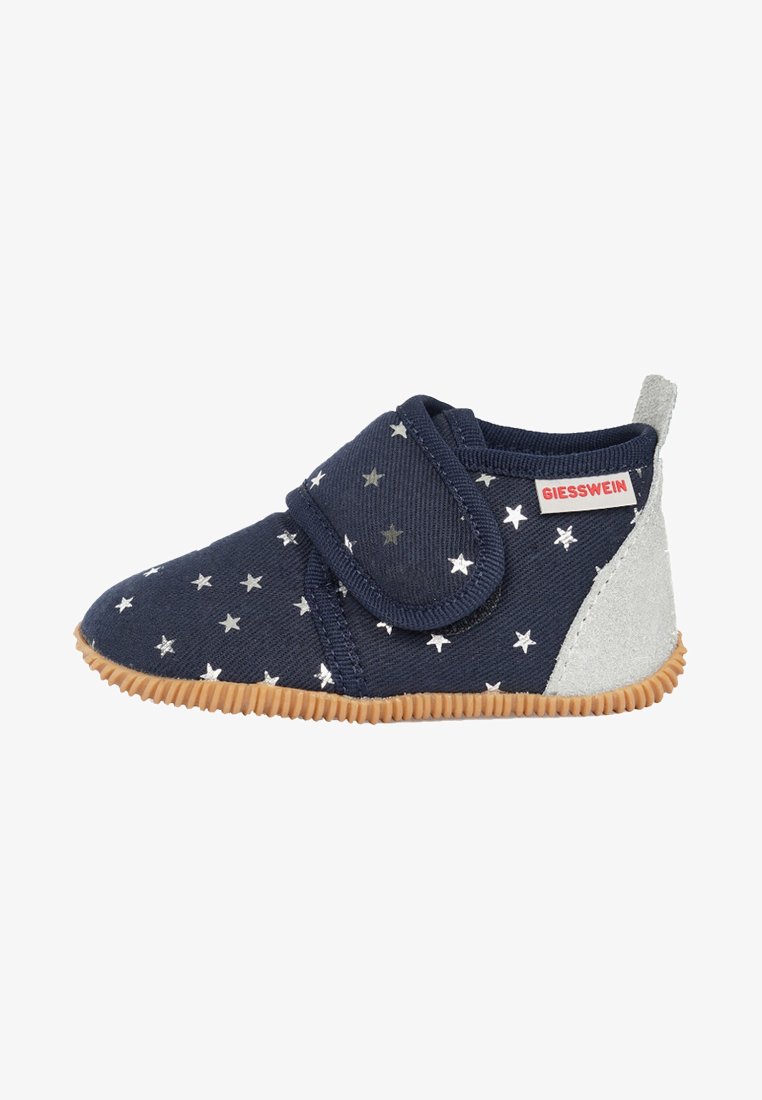 Chaussure en tissu navy avec motif d'étoiles argentées, bande auto-agrippante, talon en suède gris et semelle en caoutchouc texturé. Bout rond et design à coupe basse.