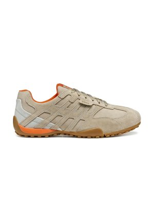 Beżowe zamszowe sneakersy z białymi i pomarańczowymi akcentami, charakteryzujące się teksturowaną powierzchnią, sznurówką z przodu oraz gumową podeszwą dla lepszej przyczepności.