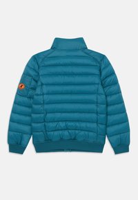 Jachetă umplută de culoare teal, cu guler înalt, manșete și tiv cu textură canelată. Prezintă o emblema portocalie pe mâneca stângă. Textură netedă.