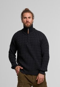Mørkeblå kabelstrikket sweater med høj krave og halv lynlås; ribbede manchetter og søm; struktureret mønster hele vejen igennem.