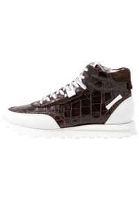 Sneaker montante avec une texture crocodile brun foncé, lacets blancs et semelle blanche, mettant en avant un col en suède et des éléments de design épurés.