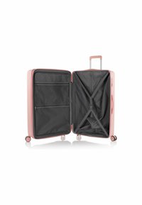 Valigia rigida rosa con doppi scomparti. L'interno presenta una fodera in tessuto nero, tasche con zip e una cinghia incrociata per fissare gli oggetti.