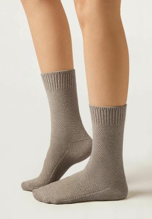 Calze grigie lavorate a maglia con un motivo testurizzato, polsini a coste e design della punta affusolato, che mostrano un aspetto morbido e confortevole.