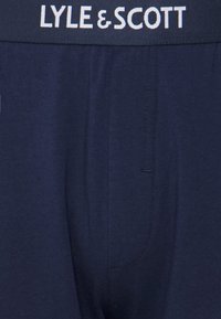 Boxer de marinho com uma mistura de algodão e uma cintura elástica apresentando "LYLE & SCOTT" em letras brancas. Textura suave.