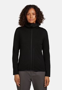 Černá bunda na zip s vysokým límcem, přiléhavým střihem a kontrastním prošitím. Má dlouhé rukávy a hladkou texturu.