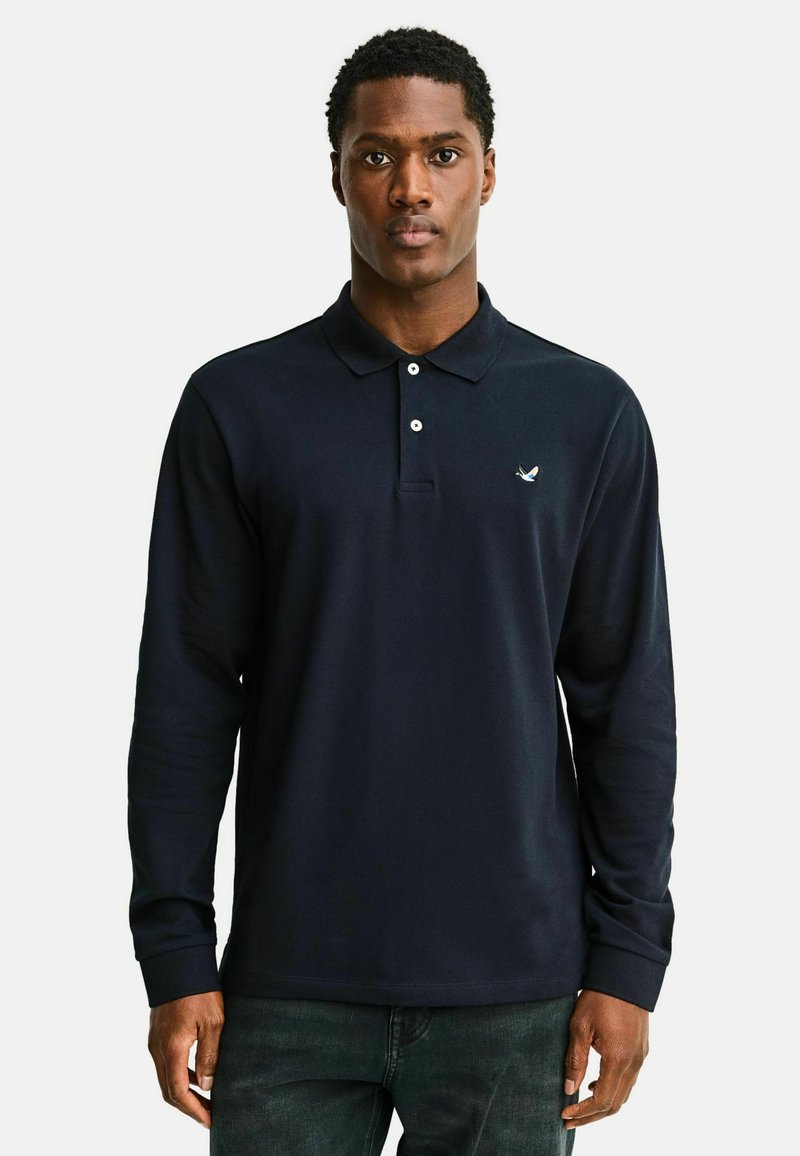 Polo de manga larga color azul marino, hecho de tela suave, cuenta con cuello, tapeta de tres botones y un pequeño logotipo en el pecho izquierdo.