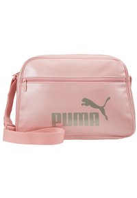 Borsa sintetica rosa con design piatto, tracolla regolabile, tasca con zip frontale e grande logo Puma grigio. Texture liscia, forma rettangolare.