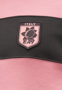 Čierne a ružové športové tričko s vodorovnými pruhmi, ktoré obsahuje nášivku s logom "ITALY EA7" a kvetinový dizajn na hrudi.
