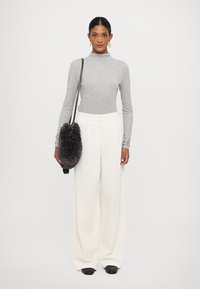 Gray long-sleeve turtleneck, white wide-leg ribbed trousers, black flat shoes, and a dark furry shoulder bag. Simple and clean design.