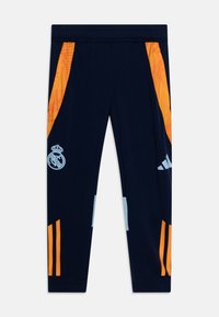 Navy athletic pants with orange and light blue accents. Features a Real Madrid logo. Made of stretchy, lightweight material.