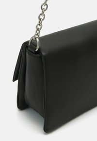 Borsa nera in pelle con forma strutturata, dotata di una tracolla a catena e dettagli di cucitura sottili, che mette in mostra una texture liscia.