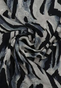 Tissu noir et gris à motifs rayés abstraits, avec une texture douce et lisse. Le matériau semble léger et fluide.