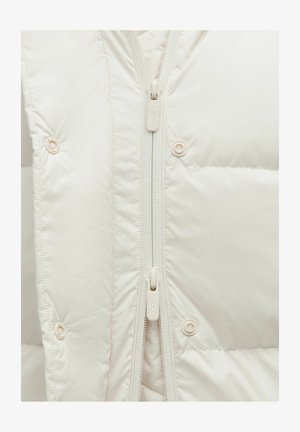 Giacca imbottita di colore crema con colletto alto, zip a tutta lunghezza e bottoni a pressione; presenta una texture liscia e lucida con dettagli cuciti.