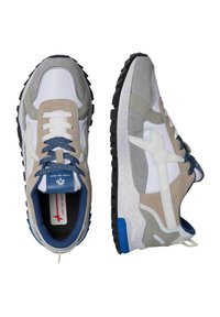 Sportiga sneakers med en blandning av vita, grå, beige och blå material. Syntetiska och mocka-texturer, gummisulor, mönstrade snörningar och kontrasterande detaljer.