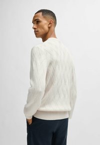 Maglione in maglia di crema chiara con un motivo a diamante testurizzato, polsini e orlo a coste, dalla vestibilità rilassata e scollo rotondo.