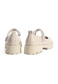 Beige gepatenteerde leren schoenen met een chunky rubberen zool, elastische band en ronde neus. Voorzien van een gegroefde buitenzool voor grip.