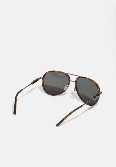Ochelari de soare din scoică cu lentile întunecate, accente metalice și un cadru rotund. Temele sunt elegante, cu un detaliu unic la balama.