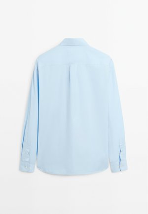 Chemise à manches longues bleu clair en tissu lisse. Dotée d'un col classique, de poignets à bouton et d'un pli central au dos pour un confort supplémentaire.