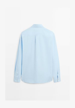 Chemise à manches longues bleu clair en tissu lisse. Dotée d'un col classique, de poignets à bouton et d'un pli central au dos pour un confort supplémentaire.