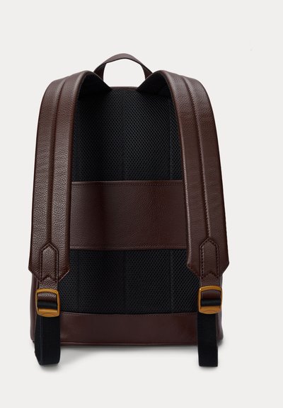 Rückansicht eines braunen Leder-Rucksacks mit gepolstertem schwarzem Mesh-Rückenpanel und verstellbaren Trägern mit goldfarbenen Schnallen.