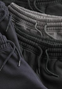 Baumwoll-Sweatpants in Dunkelgrau, Anthrazit und Schwarz. Mit einem elastischen Bund mit Kordelzug, weichem Material und lässigem Design.