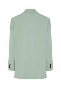 Lys grønn blazer med strukturert, skreddersydd design, enkeltspent stil, hakkede slag og fire svarte knapper på ermene.