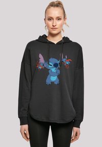 Svart hettegenser med et frontgrafikk av en blå animerte karakter, med store ører og lekne detaljer i rødt og blått.