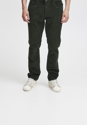 Donkergroene corduroy broek met een rechte pasvorm, voorzien van zakken aan de voorkant en een knoopsluiting, gecombineerd met witte sneakers.