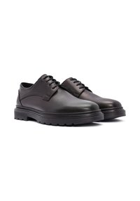 Chaussures en cuir noir à lacets avec une surface lisse, bout arrondi et semelle en caoutchouc épaisse dotée d'un profil texturé pour une meilleure adhérence.