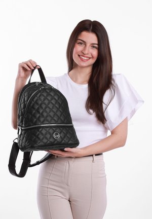 Black quilted backpack with glossy finish, dual zippers, and rounded shape. Features top handle and adjustable straps. Logo on front.
