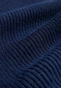 Mørkeblå ribbet stof med fin tekstur, der har fremtrædende horisontale linjer og et blødt, fuzzy udseende. Ideelt til varme tøj eller accessories.