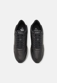 Svarta lädersneakers med rund tå, strukturerad ovandel och snördesign. Vita detaljer på hälen och varumärkeslogotypen på tungan.