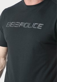 Černé tričko vyrobené z hladké látky s vyvýšeným, lesklým logem 883POLICE přes prsa. Klasický design s kulatým výstřihem.