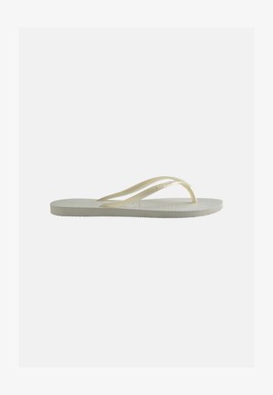 Vienas dramblio kaulo spalvos guminis šlepetės tipo sandalėlis su plonomis dirželiais ir tekstūruota pado dalimi, matomas iš šono ant paprasto fono.