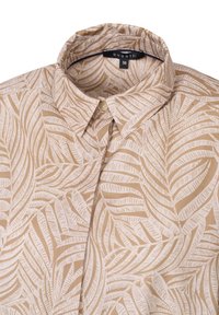 Light brown shirt featuring a leaf pattern in a cream color, with a standard collar and single button placket. Material appears smooth.