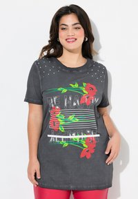 Mørkegrå bomulds t-shirt med korte ærmer, der har røde blomster grafik og teksten "VÆR GLAD." Accentueret med sølvnitter på skuldrene.