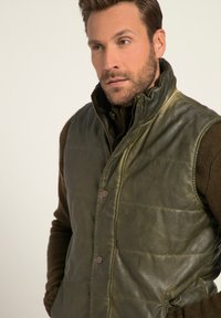 Grünes Lederweste mit hohem Kragen, Reißverschluss und Knopfdetails; gestepptes Design, strukturierte Oberfläche und seitliche Taschen.