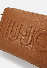 Borsa in pelle marrone con texture, caratterizzata dal logo 'LIU·JO' in rilievo, bordi lisci e zip in hardware dorato.