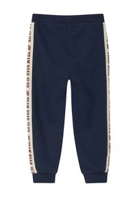 Navy Jogginghose aus weichem Material, mit beigen seitlichen Streifen und rotem Aufdruck. Mit Gummizug an der Taille und aufgerollten Knöcheln für zusätzlichen Komfort.